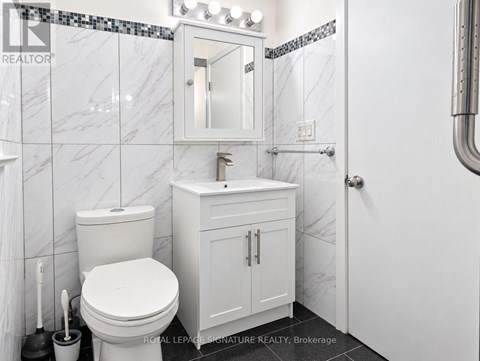 A white toilet and sink in a bathroom.