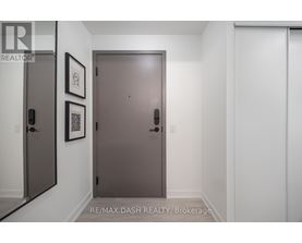 A hallway with a brown door and two framed pictures on the wall.