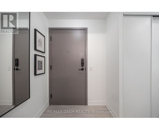 A hallway with a brown door and two framed pictures on the wall.