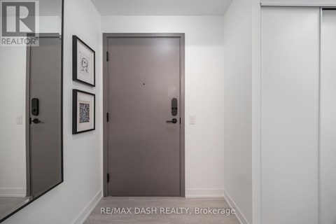 A hallway with a brown door and two framed pictures on the wall.