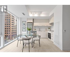 A modern kitchen with a glass table and chairs, a fridge, a microwave, and a stove.