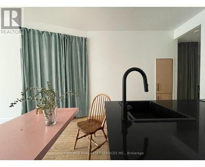 A kitchen with a black counter and a chair.