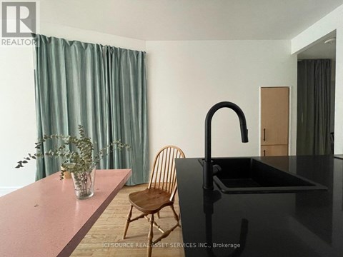 A kitchen with a black counter and a chair.