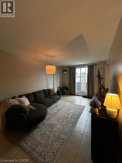 A living room with a black couch and a lamp on a table.