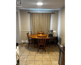A dining room with a table and chairs.