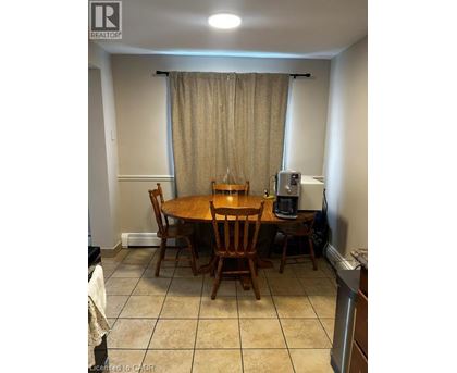 A dining room with a table and chairs.