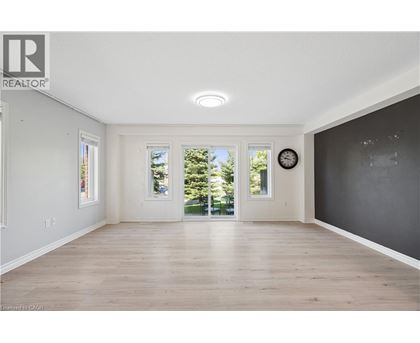 A spacious room with wooden floors and a large window.