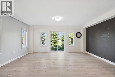 A spacious room with wooden floors and a large window.