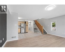 A spacious living room with a staircase leading to the upper floor.