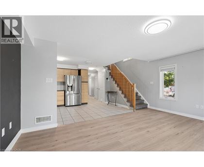 A spacious living room with a staircase leading to the upper floor.