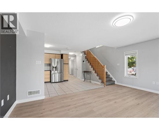 A spacious living room with a staircase leading to the upper floor.