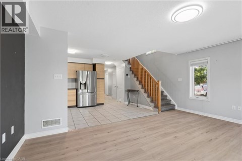 A spacious living room with a staircase leading to the upper floor.
