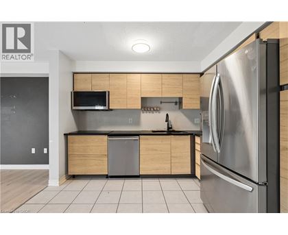 A modern kitchen with a stainless steel refrigerator and wooden cabinets.