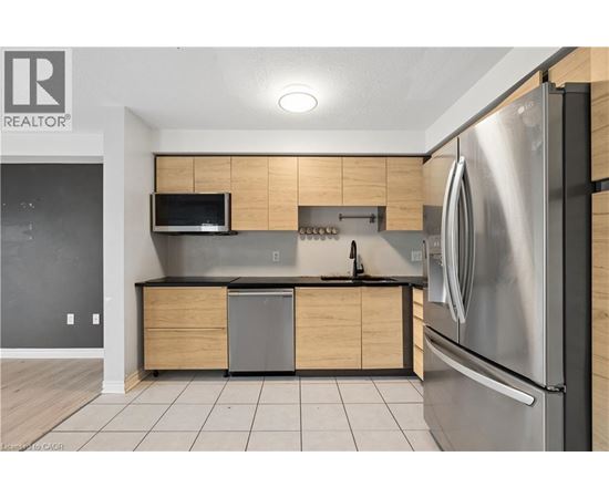 A modern kitchen with a stainless steel refrigerator and wooden cabinets.
