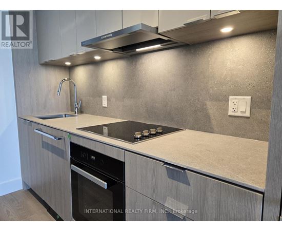 A modern kitchen with a stainless steel oven and a granite countertop.