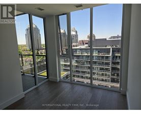 A room with a view of the cityscape through large windows.