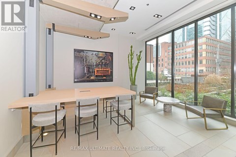 A conference room with a long table and chairs, a poster on the wall, and a view of the city outside the windows.