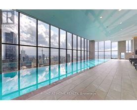 A large room with a pool and a view of the city.