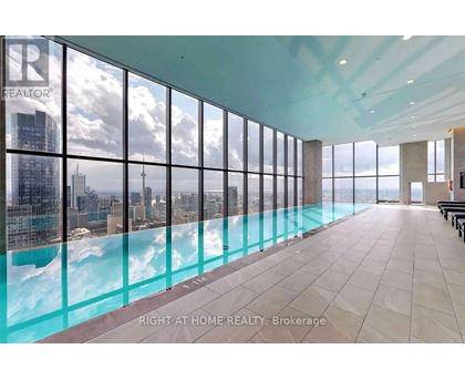A large room with a pool and a view of the city.