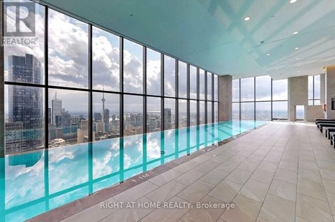 A large room with a pool and a view of the city.