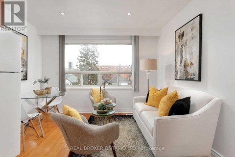 A living room with a white couch and a glass table.