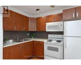 A kitchen with brown cabinets and white appliances.