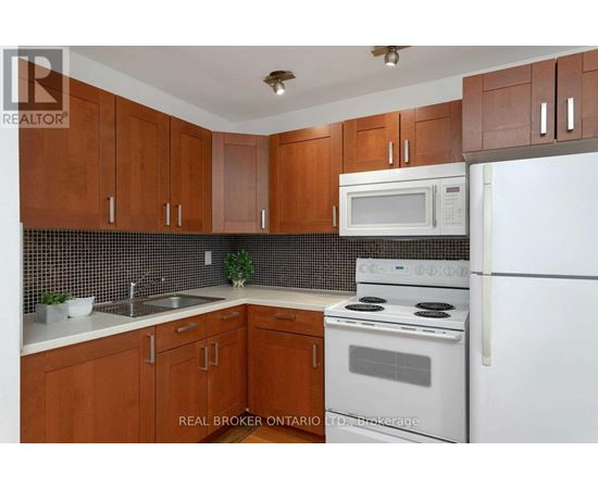 A kitchen with brown cabinets and white appliances.