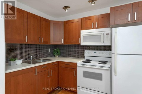 A kitchen with brown cabinets and white appliances.