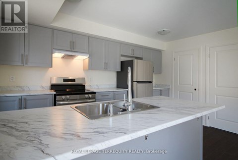 A kitchen with a marble counter top and stainless steel appliances.