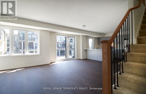 A spacious room with a staircase leading to the upper floor.