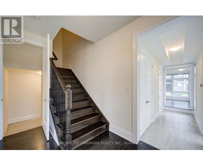 A staircase with a wooden handrail leads to a second floor.