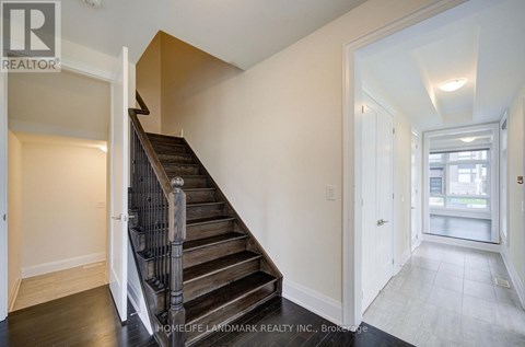 A staircase with a wooden handrail leads to a second floor.