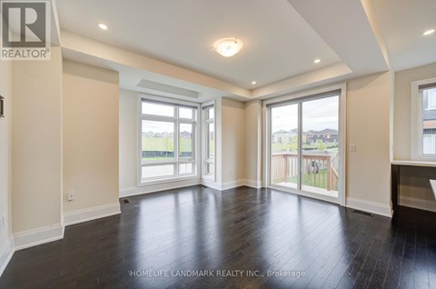 A spacious room with a sliding glass door leading to a balcony.