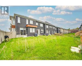 A row of houses with a grassy area in front.