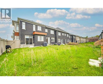 A row of houses with a grassy area in front.