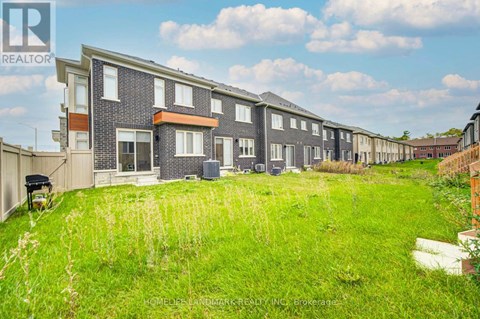 A row of houses with a grassy area in front.