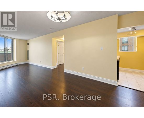 A spacious room with wooden floors and a ceiling light fixture.
