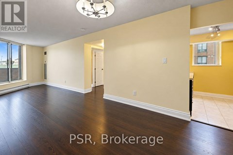 A spacious room with wooden floors and a ceiling light fixture.