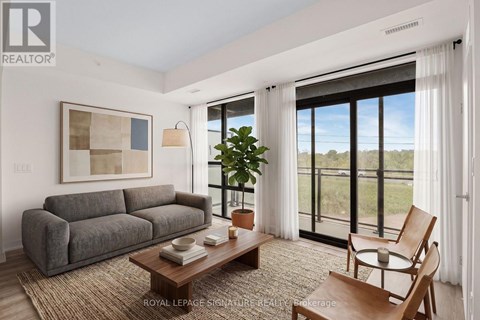 A living room with a grey couch, a wooden coffee table, and a painting on the wall.