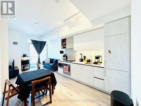 A modern kitchen with white cabinets and a black table.