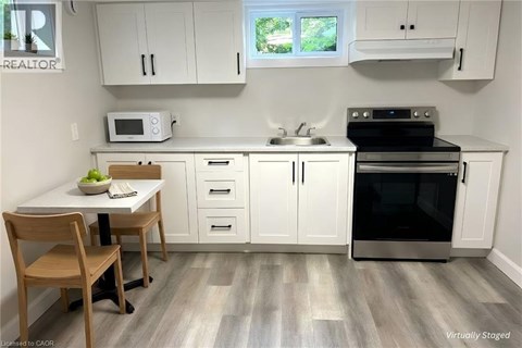 A kitchen with white cabinets and a wooden table.