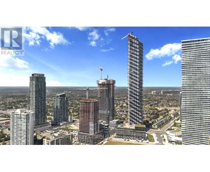 A cityscape with a clear blue sky and several high-rise buildings, one of which is under construction.