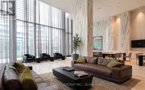 A living room with a brown couch and a coffee table in front of a large window.