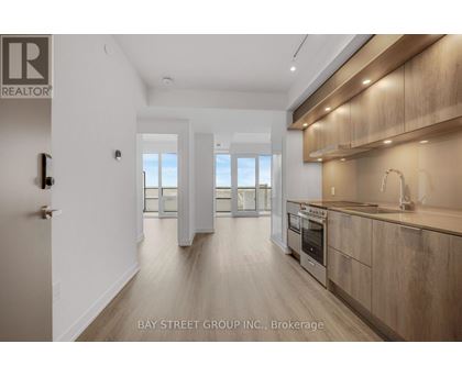 A modern kitchen with wooden cabinets and a stainless steel oven.