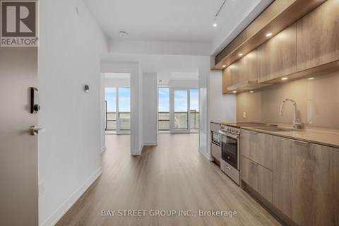 A modern kitchen with wooden cabinets and a stainless steel oven.