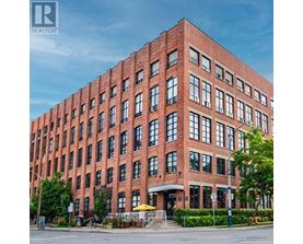 A large red brick building with many windows and a sign that says "REALTOR".