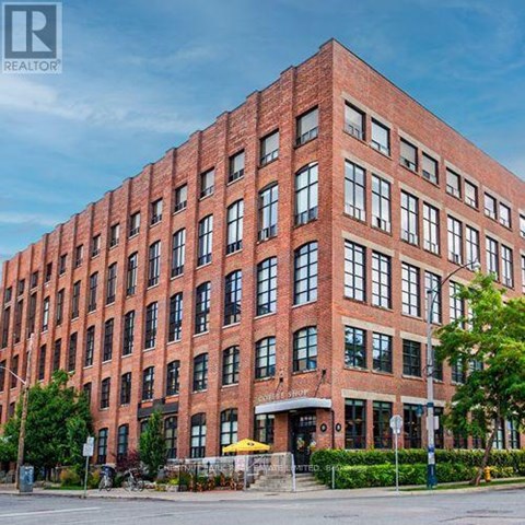 A large red brick building with many windows and a sign that says "REALTOR".