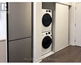 A white washing machine is in a small laundry room.