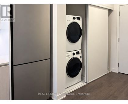 A white washing machine is in a small laundry room.