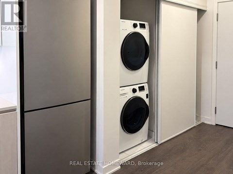 A white washing machine is in a small laundry room.